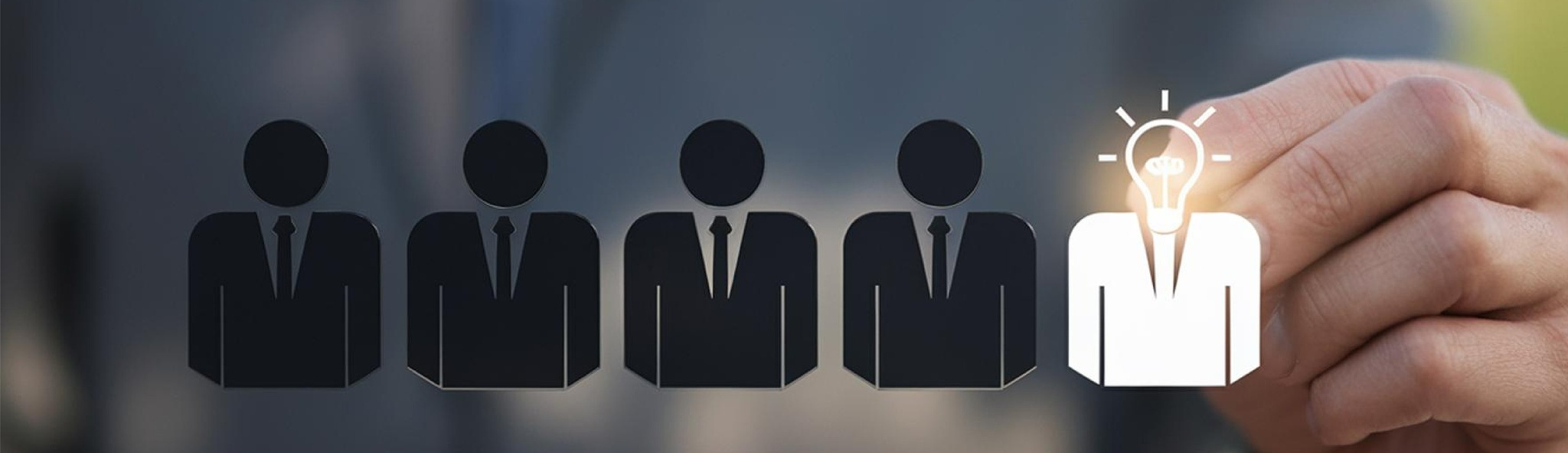 Row of business figures with one highlighted by a glowing light bulb