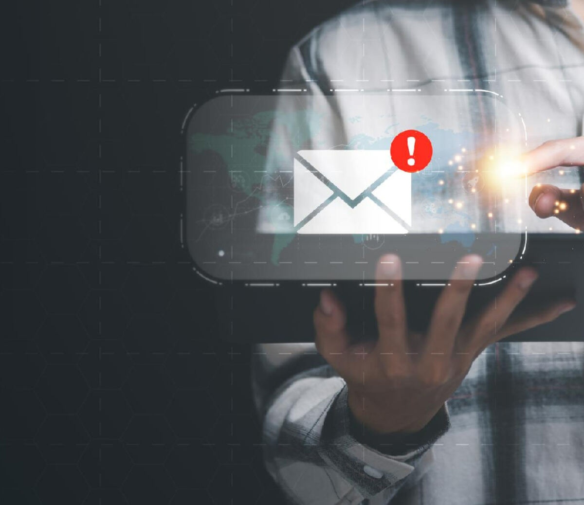 Person holding a tablet with a glowing email alert icon
