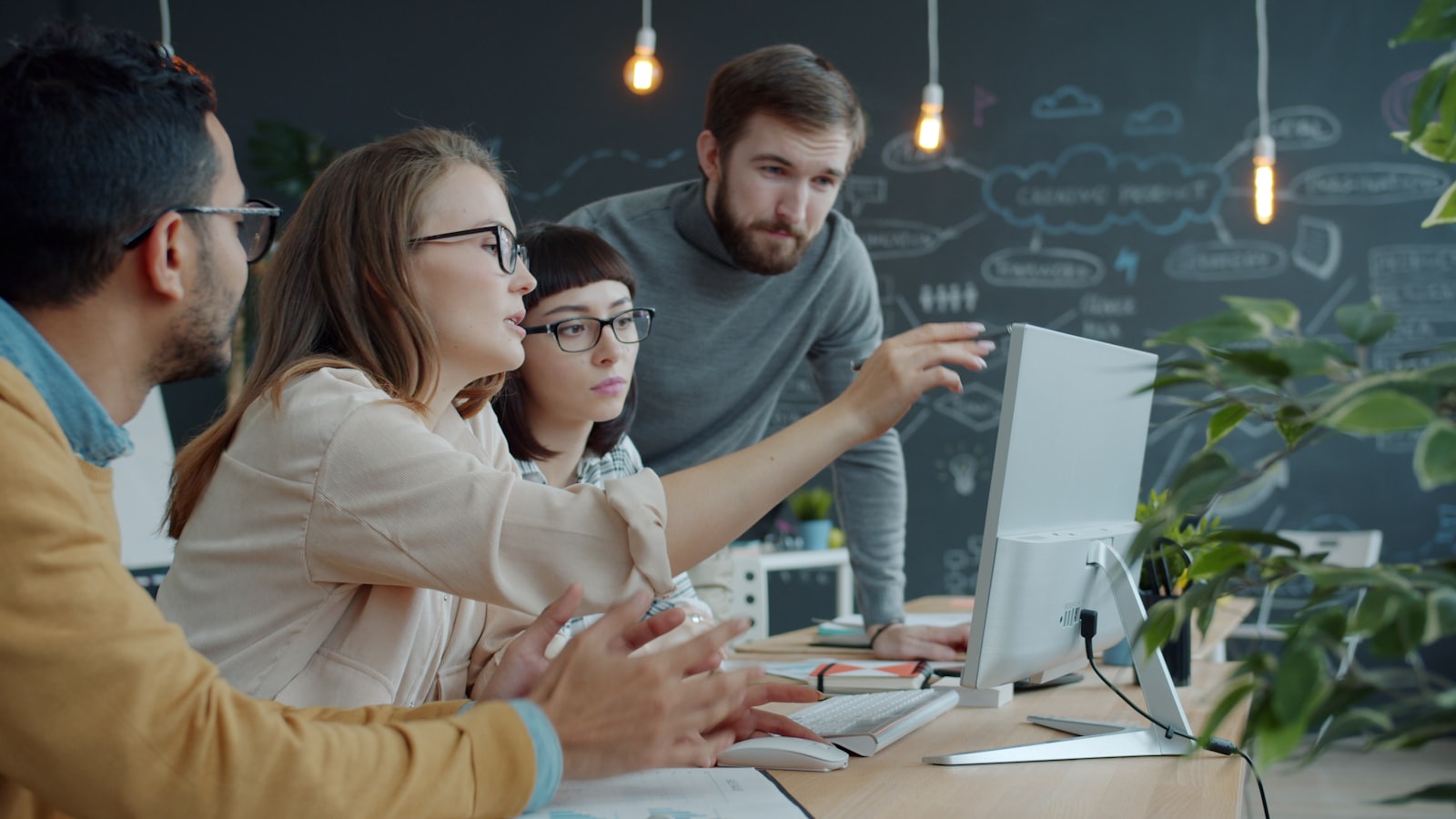 Product engineers reviewing an interface design together on a desktop monitor
